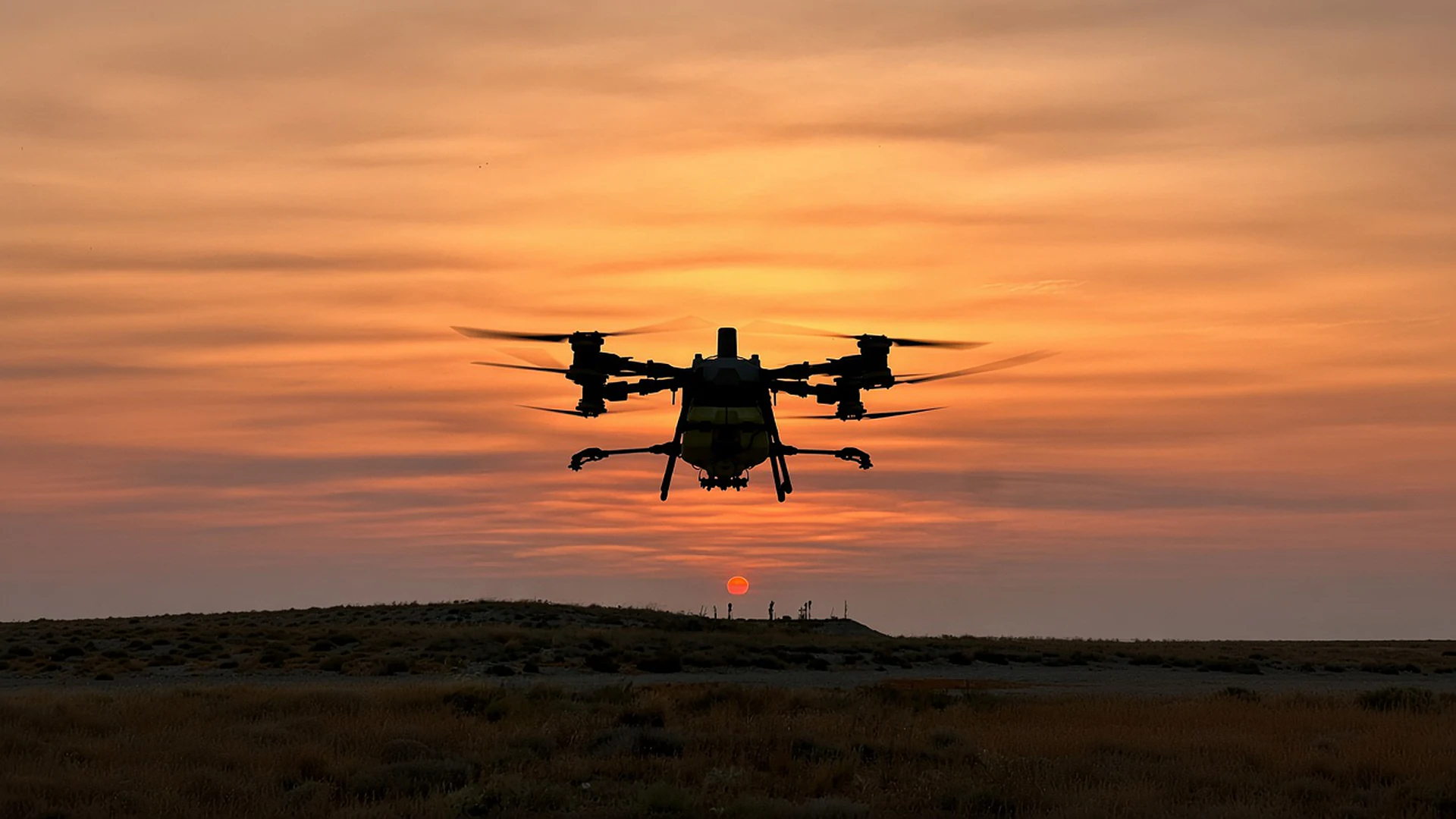 Silueta de un dron agrícola volando al atardecer sobre el campo